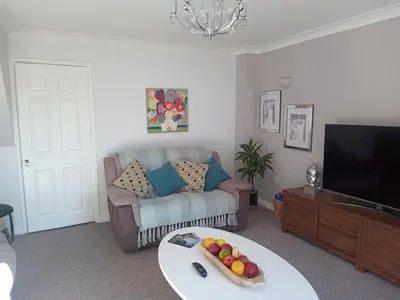 a living room with a couch and a tv at Ludlow Mews Town House with Free parking in Ludlow
