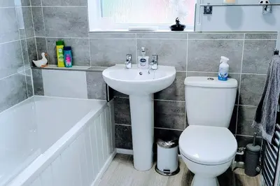 a bathroom with a sink and a toilet and a tub at Ludlow Mews Town House with Free parking in Ludlow