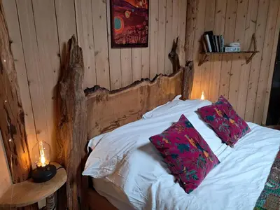 a bedroom with a bed with two pillows on it at Magical Offgrid Roundhouse in Eryri in Machynlleth