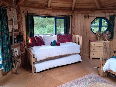 a bedroom with a bed in a wooden room at Magical Offgrid Roundhouse in Eryri in Machynlleth