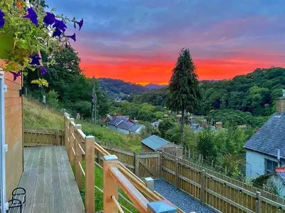 a wooden fence with a sunset in the background at Castle View chalet in Llangollen