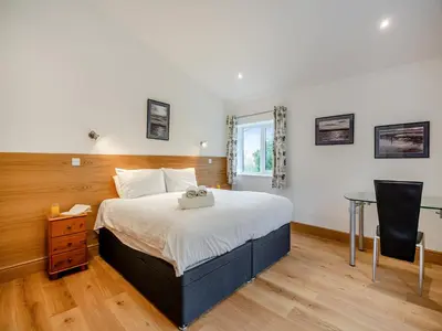 a bedroom with a large bed and a desk at Bodwennol in Aberdyfi