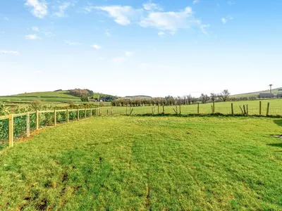 a field of green grass with a fence at Sunflower - Uk42360 in Saint Harmon
