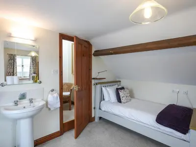 a bathroom with a bed and a sink and a mirror at The Old Coach House -Uk41272 in Great Hanwood