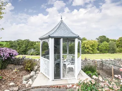 a gazebo in the middle of a garden at The Old Coach House -Uk41272 in Great Hanwood