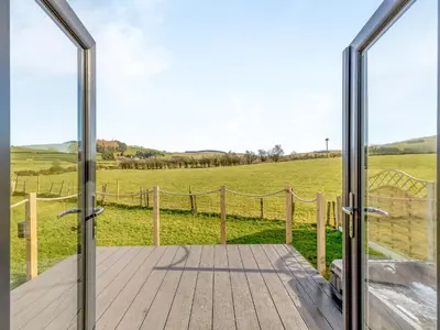 an open door to a deck with a view of a field at Tulip - Uk42363 in Saint Harmon
