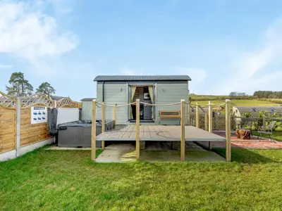 a tiny house with a deck in a yard at Tulip - Uk42363 in Saint Harmon