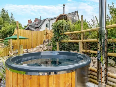 a hot tub in a backyard with a fence at The Lodge Spa - Uk47837 in Church Pulverbatch