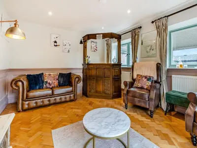 a living room with leather furniture and a table at The Lodge Spa - Uk47837 in Church Pulverbatch