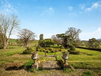 a cemetery with two vases in a field at Apartment At Llanerchydol Hall in Welshpool