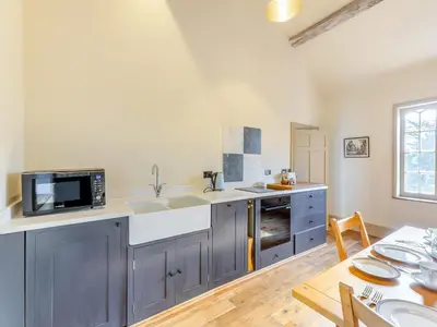 a kitchen with a sink and a microwave at Apartment At Llanerchydol Hall in Welshpool