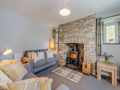 a living room with a couch and a stone fireplace at East Llwyn - Uk41756 in Rhyd Owen