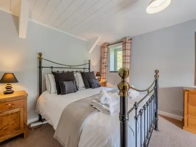 a bedroom with a large bed and a window at East Llwyn - Uk41756 in Rhyd Owen