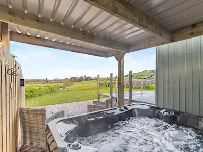 a hot tub on the patio of a house at Mayflower - Uk42359 in Saint Harmon