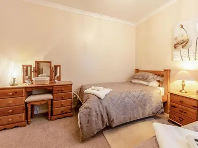 a bedroom with a bed and a desk and a mirror at Snowdrop in Llanerch-Aeron