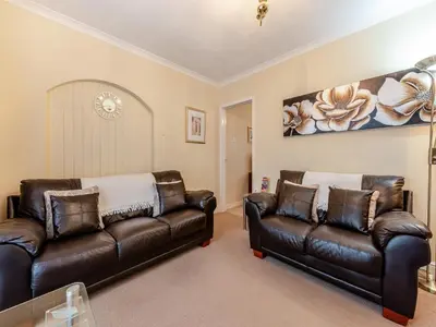 a living room with two leather couches at Snowdrop in Llanerch-Aeron
