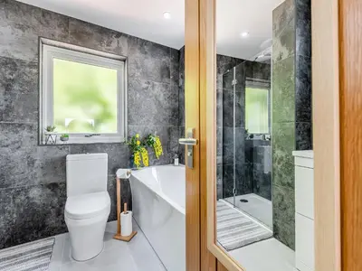 a bathroom with a toilet and a tub and a shower at Llwynblyfyn in Llansawel