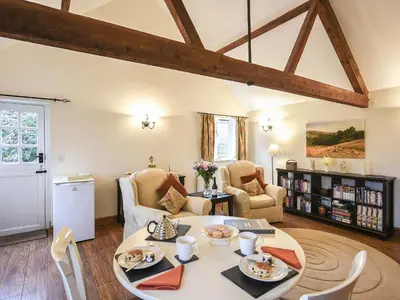 a living room with a table and chairs at The Corn House - Cottage in Great Hanwood