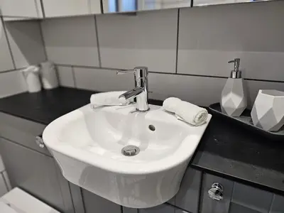 a white sink in a bathroom with a black counter at MODERN 3 BEDROOM PROPERTY WITH FREE DRIVEWAY PARKING by SHIRE STAYS in Shrewsbury