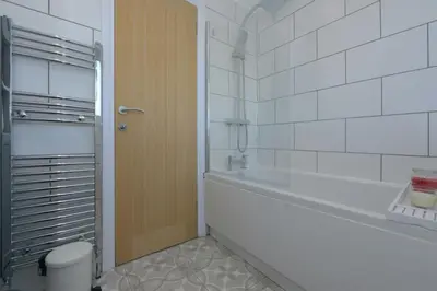 a bathroom with a shower and a toilet and a door at MODERN 3 BEDROOM PROPERTY WITH FREE DRIVEWAY PARKING by SHIRE STAYS in Shrewsbury