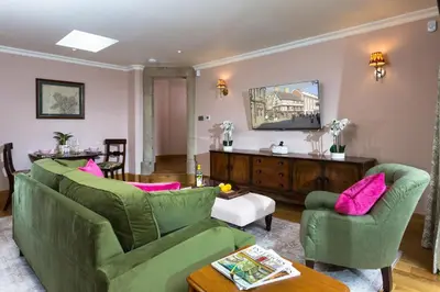 a living room with two green couches and pink pillows at Bryngwilla Gate Lodge in Oswestry