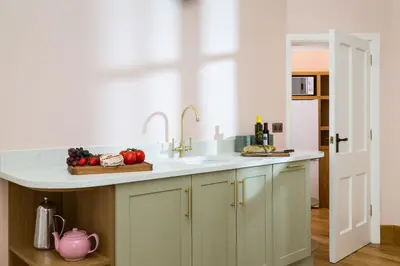a kitchen with a sink and a pink tea kettle at Bryngwilla Gate Lodge in Oswestry