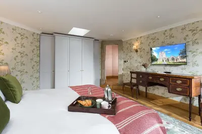 a bedroom with a bed with a tray of food on it at Bryngwilla Gate Lodge in Oswestry