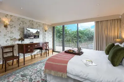 a bedroom with a bed and a desk and a window at Bryngwilla Gate Lodge in Oswestry