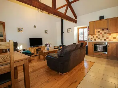a living room with a couch and a tv at The Cart House in Shrewsbury