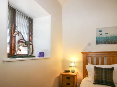 a bedroom with a bed with a toy horse on a window at The Cart House in Shrewsbury