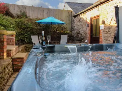 a plunge pool with an umbrella in a backyard at The Cart House in Shrewsbury