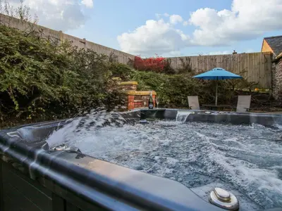 a plunge pool with water in a backyard with an umbrella at The Cart House in Shrewsbury