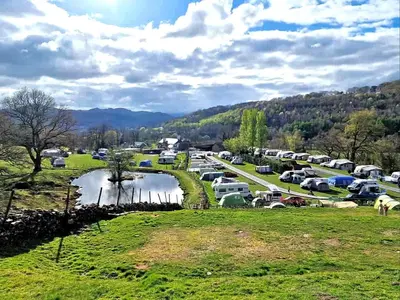 a parking lot with cars parked next to a river at Bunkhouse Accommodation in the Heart of Snowdonia in Dolgellau