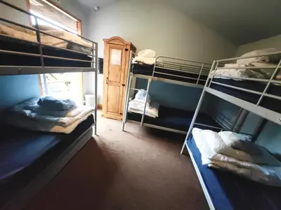 a room with three bunk beds and a window at Bunkhouse Accommodation in the Heart of Snowdonia in Dolgellau