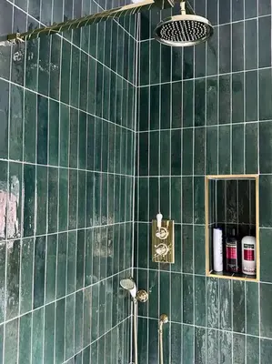 a green tiled bathroom with a shower and a mirror at Charming Townhouse Retreat in Shrewsbury