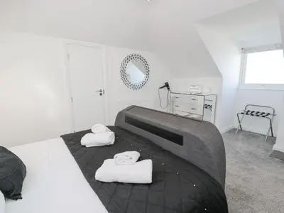 a bedroom with a bed with towels on it at The Gables in Tywyn