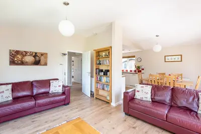 a living room with two red couches and a kitchen at Ash Lodge in Craven Arms