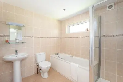 a bathroom with a toilet and a sink and a bath tub at Ash Lodge in Craven Arms
