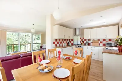 a kitchen and dining room with a wooden table with chairs at Ash Lodge in Craven Arms