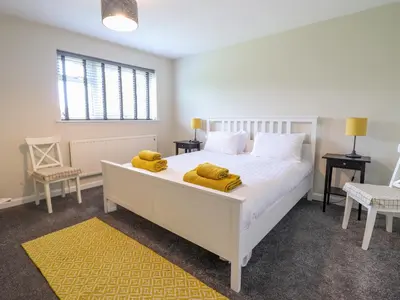 a bedroom with a white bed with yellow towels on it at The Wardens House in Newtown