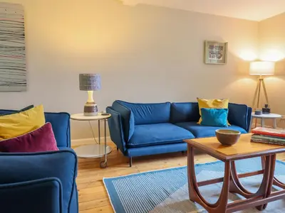 a living room with blue couches and a table at The Wardens House in Newtown