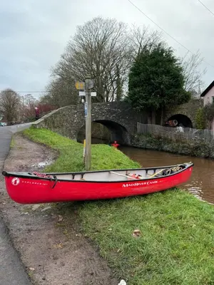 a red boat sitting on the side of a river at 3 bedroom cottage Brecon sleeps 4 in Brecon