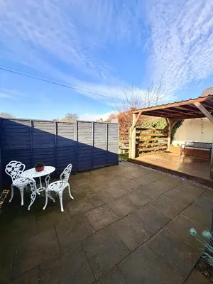 a patio with two white chairs and a table at 3 bedroom cottage Brecon sleeps 4 in Brecon