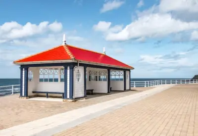 a pavilion on a beach with the ocean in the background at Gorgeous Sea Viev 3 Bedroom Delta Bromley Deluxe in Aberystwyth