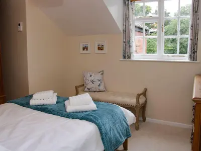 a bedroom with two beds and a window at Troutbeck Cottage in Ludlow