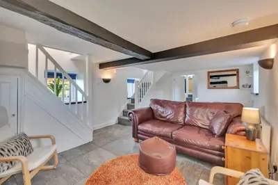 a living room with a brown leather couch at Trinity Cottage in Welshpool