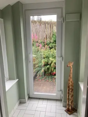 a door with a giraffe standing in a hallway at Trinity Cottage in Welshpool