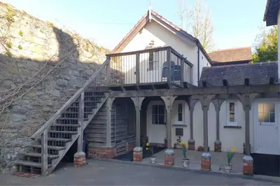 a house with a staircase leading up to a house at Craig Fach Coach House in Builth Wells