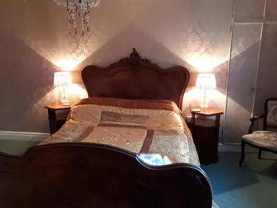 a bedroom with a large wooden bed with two lamps at Llew Coch B&B formerly The Red Lion inn in Llanfihangel-nant-Melan