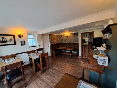 a living room with wooden floors and a dining room at Llew Coch B&B formerly The Red Lion inn in Llanfihangel-nant-Melan